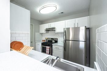 A kitchen with stainless steel appliances and white cabinets
