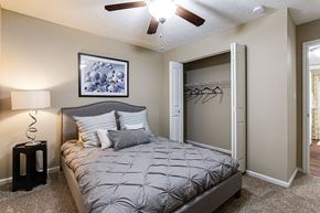 Peachtree Corners apartment for rent - a bedroom with a bed and closet with a ceiling fan