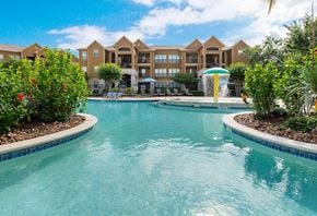 Beaumont apartment for rent - a large swimming pool with a fountain and a hotel in the background