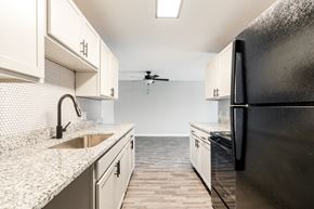 Indianapolis apartment for rent - a kitchen with white cabinets and a black refrigerator
