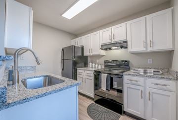 Indianapolis apartment for rent - A kitchen with white cabinets and a granite countertop.