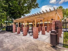 Indianapolis apartment for rent - a patio with brick pillars and a wooden pavilion with tables
