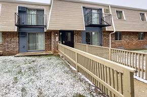 Madison apartment for rent - a balcony with a wooden fence in front of a brick house