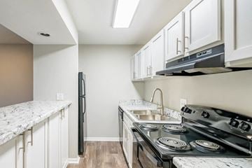 Madison apartment for rent - A kitchen with a black refrigerator and stove top oven.