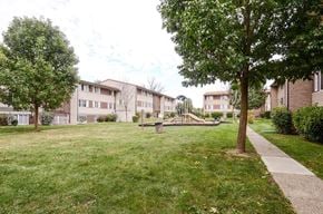 Indianapolis apartment for rent - a park with grass and trees in front of apartment buildings