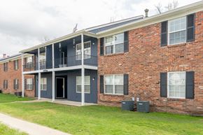 Indianapolis apartment for rent - the front of a brick apartment building with a porch and a sidewalk
