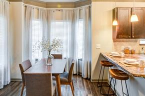 Prattville apartment for rent - a dining room with a table and chairs and a kitchen with windows at Century HomePlace, Alabama