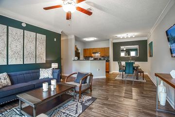 College Park apartment for rent - A living room with a dark blue couch and a wooden coffee table.