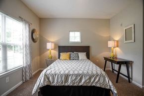 College Park apartment for rent - A bedroom with a patterned bedspread and two lamps on side tables.