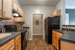 College Park apartment for rent - a kitchen with black appliances and wooden cabinets
