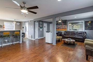 Atlanta apartment for rent - A living room with a black leather couch and a ceiling fan.