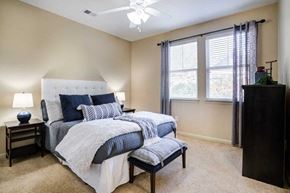 Birmingham apartment for rent - a bedroom with a bed and a chair and a ceiling fan at Century Lakeshore Crossings, Birmingham, 35211
