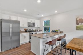 Gray apartment for rent - A kitchen with a refrigerator, microwave, oven, and sink.