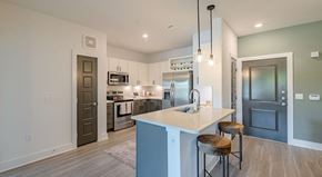 Frisco apartment for rent - A modern kitchen with a large island and stools.