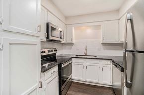 Prairie Village apartment for rent - A kitchen with white cabinets and black countertops.