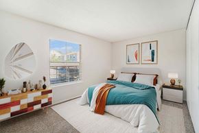 Prairie Village apartment for rent - A bedroom with a bed, nightstand, and a window with blinds.