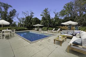 Prairie Village apartment for rent - A pool surrounded by patio furniture and umbrellas.