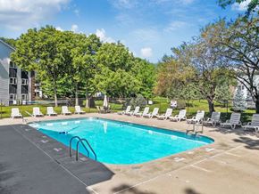 West Des Moines apartment for rent - A swimming pool surrounded by trees and lounge chairs.