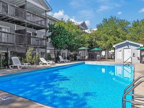Urbandale apartment for rent - A swimming pool in front of a building with a white chair.