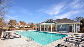 Newnan apartment for rent - A swimming pool with sun loungers and a building in the background.