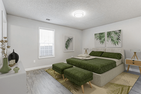 Newnan apartment for rent - A bedroom with a large bed and a green rug.