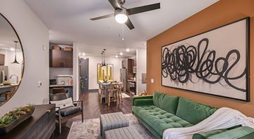 Jacksonville apartment for rent - A living room with a green couch and a large abstract painting on the wall.