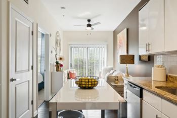 A kitchen with a white countertop and a ceiling fan.