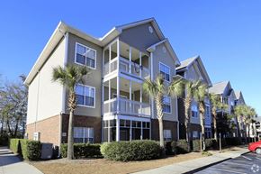 Moncks Corner apartment for rent - A building with a red car parked in front.