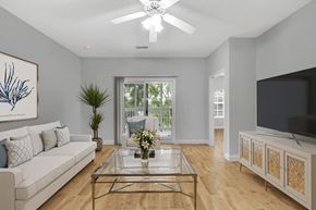 Moncks Corner apartment for rent - A living room with a white couch, a glass coffee table, and a television.