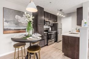 Gahanna apartment for rent - A kitchen with a table and chairs in front of a painting.