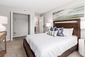 Gahanna apartment for rent - A bedroom with a large bed and a painting on the wall.