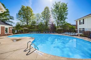 Gahanna apartment for rent - A swimming pool surrounded by trees and chairs.