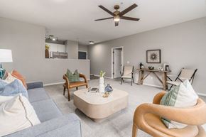 Columbus apartment for rent - A living room with a blue couch, a wooden chair, and a coffee table.