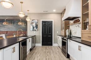 Columbus apartment for rent - A kitchen with black and white cabinets and a black door.