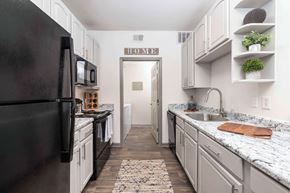 Savannah apartment for rent - A kitchen with a black refrigerator and white cabinets.