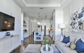 Alpharetta apartment for rent - A living room with a grey couch and a television on the left side.