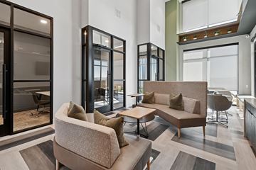 Euless apartment for rent - A modern living room with a large sofa and a glass door.