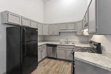 Smyrna apartment for rent - A kitchen with a black refrigerator and a black stove top oven.