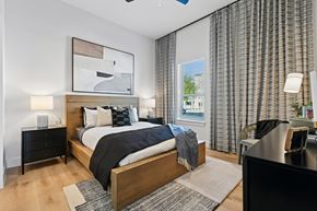 Euless apartment for rent - A bedroom with a large bed and a painting above it.