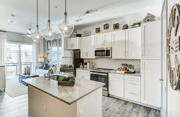 Irving apartment for rent - A kitchen with white cabinets and a marble countertop.
