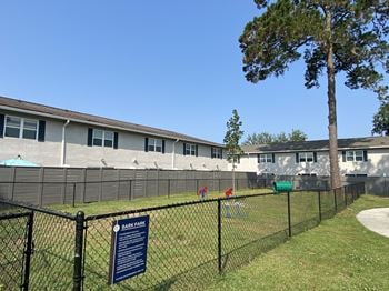 A large building with a dog park in front of it