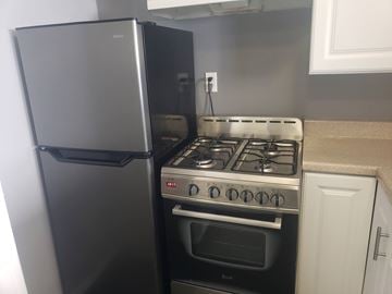 Los Angeles apartment for rent - A black refrigerator is next to a stove in a kitchen.