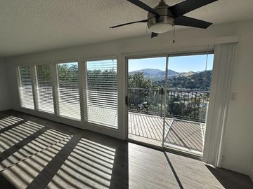 San Rafael apartment for rent - A room with a ceiling fan and a view of the mountains outside.