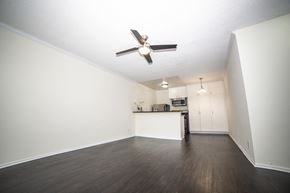 Encino apartment for rent - an empty living room with a ceiling fan and a kitchen in the background