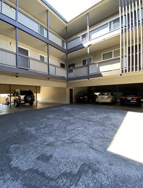 San Mateo apartment for rent - an empty parking lot with cars parked under a building