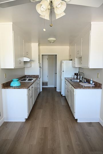 San Jose apartment for rent - a kitchen with white cabinets and white appliances and wood floors