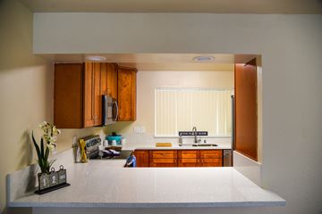 San Jose apartment for rent - a kitchen with a white counter top and wooden cabinets