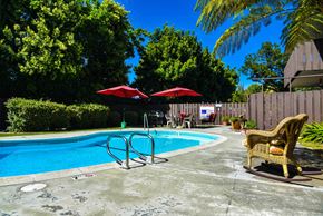 San Jose apartment for rent - a pool in a backyard with a chair and umbrellas