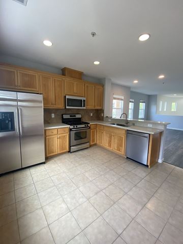 San Jose townhouse for rent - A kitchen with wooden cabinets and stainless steel appliances.
