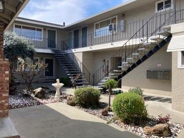 San Jose apartment for rent - A building with a staircase and a fountain in front.